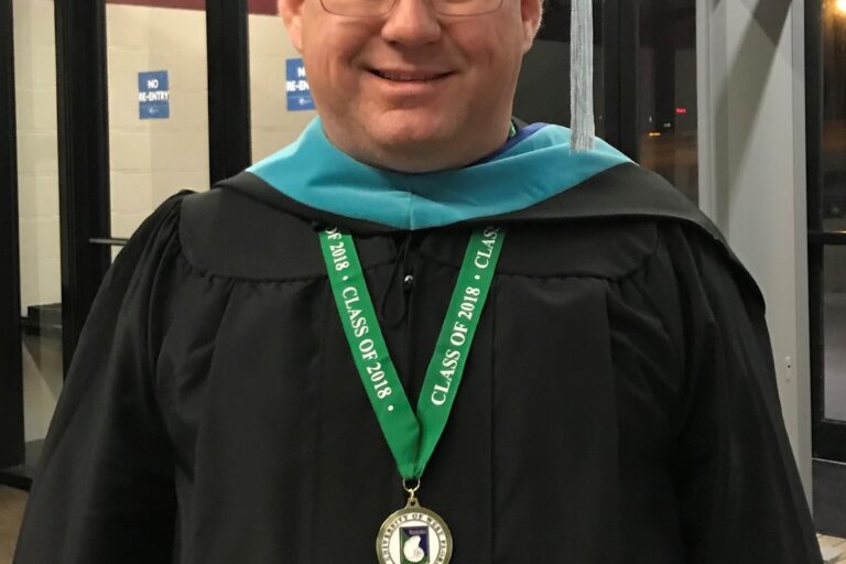Graduation graduate Rafael Deliz in cap and gown at Pensacola State College Foundation event.