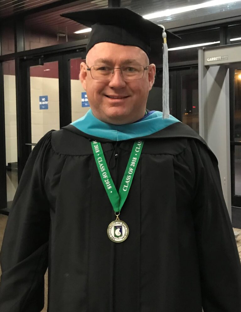 Graduation graduate Rafael Deliz in cap and gown at Pensacola State College Foundation event.