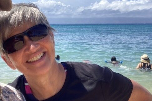 Beachside photo of Kathy Vandyck smiling at the beach.
