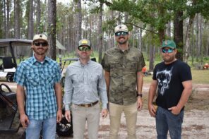 Outdoor shot of four men at the Day of Clays 2025 event in a wooded area.