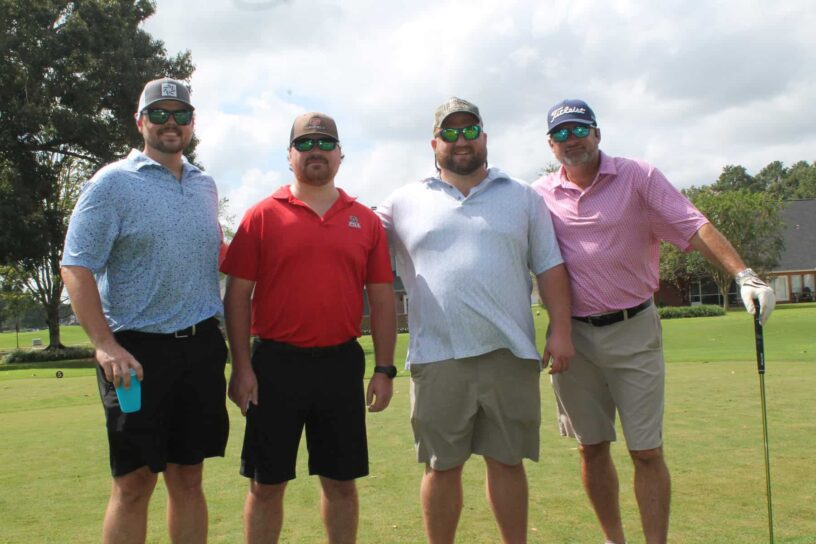 Jesse Johnson, Cody Lowe, Caleb Connell, and Joshua Ruth of Team Baby Ruth's pose together on a golf course.