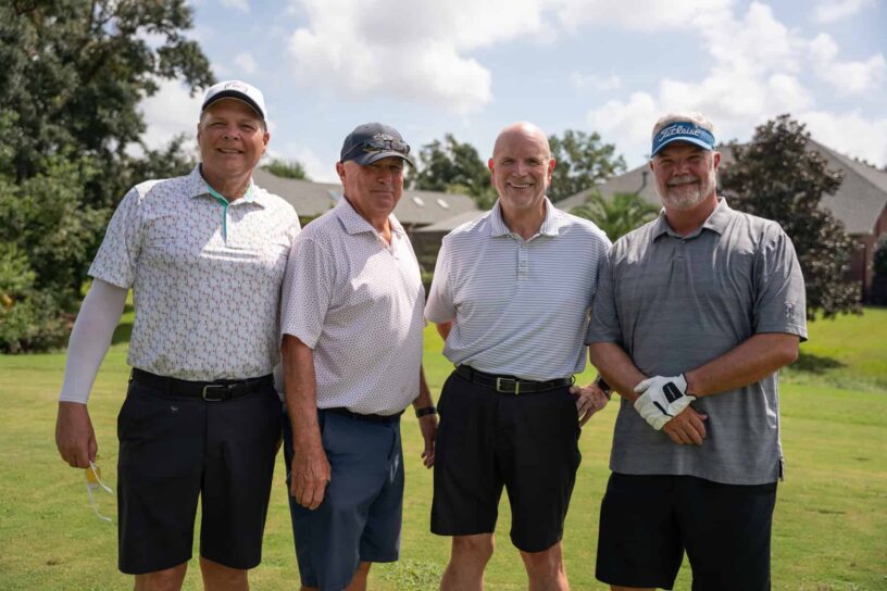 Keith Howard, Dick Hanson, John Isbell, and Kirk Albright of Team Buffalo Rock/Brokers Unlimited pose together on a golf course.
