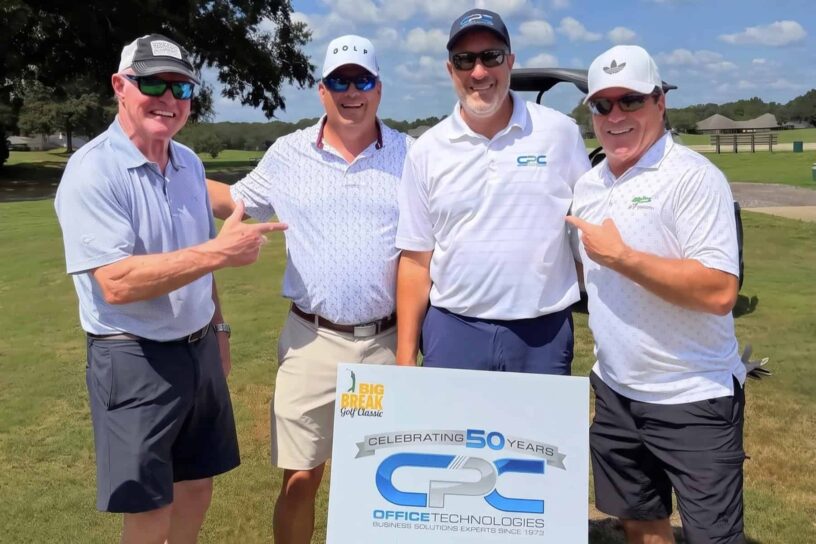 David Bonnell, Jayson Stewart, Gregg Koontz, and Jonathon Bixby of Team CPC Office Technologies pose together on a golf course.
