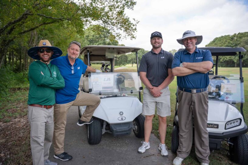 Jay Collette, Matt Ables, Tucker Mandell, and Marty Stanovich of Team LJA Engineering pose together on a golf course.