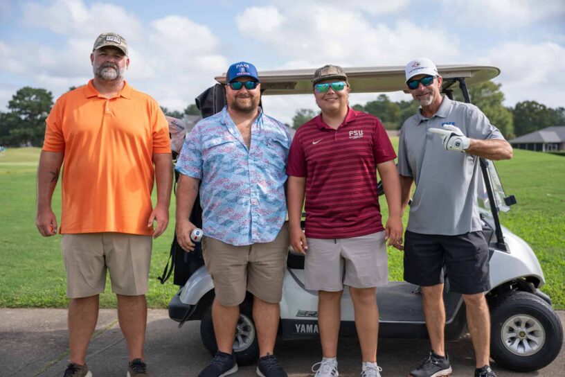 Eric Ervin, William Taylor, Gavin Rivenbark, and Jeremy Hamm of Team Pace Water Systems pose together on a golf course.