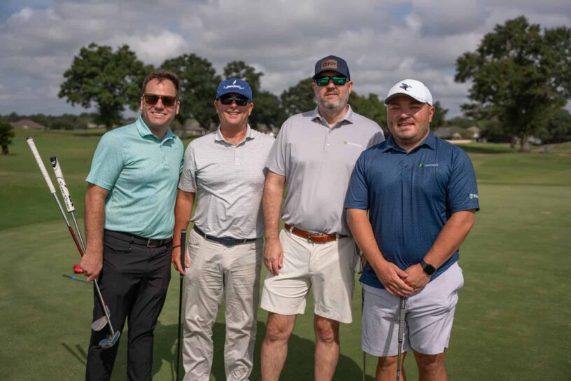 Wiley Morgan, Bill Hayes, Robbie Yeats, and Chris Harvey of Team RJ Young pose together on a golf course.