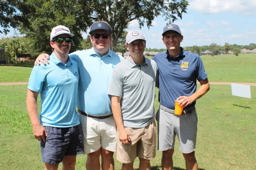Robo Whibbs, Mike Price, Brian Koontz, and Charlie Sherrill of Team SouthState Bank pose together on a golf course.