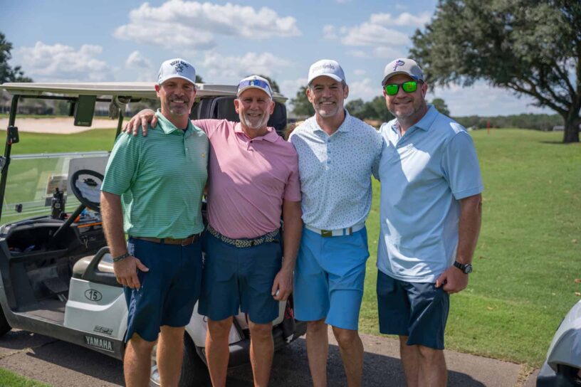 Bubba Peters, Jeff Ishee, Brett Barrow, and Rick McClanahan of Team Synovus pose together on a golf course.
