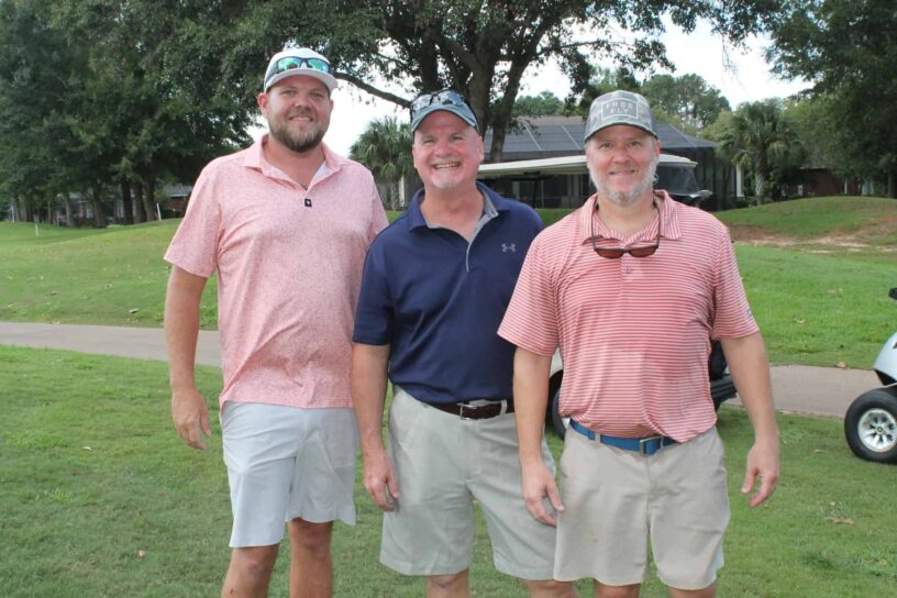 Jonathon Seaton, Shane Elkins, and Jason Brady of Team The FORE Horsemen pose together on a golf course.